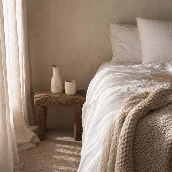 Folded beige linens on a shelf